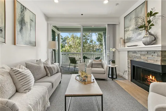 a living room with furniture a large window and a fireplace