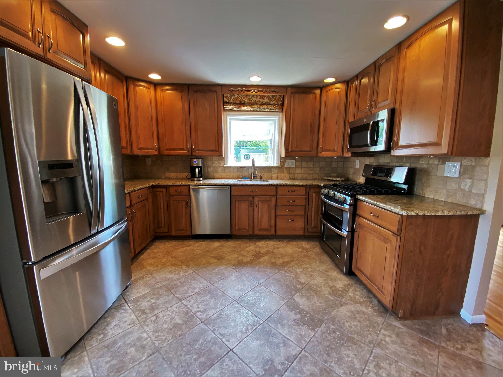 555 Tarrington Road Cherry Hill, NJ 08034 - Photo 12 of 19 a large kitchen with stainless steel appliances granite countertop a stove a sink dishwasher a refrigerator and a microwave