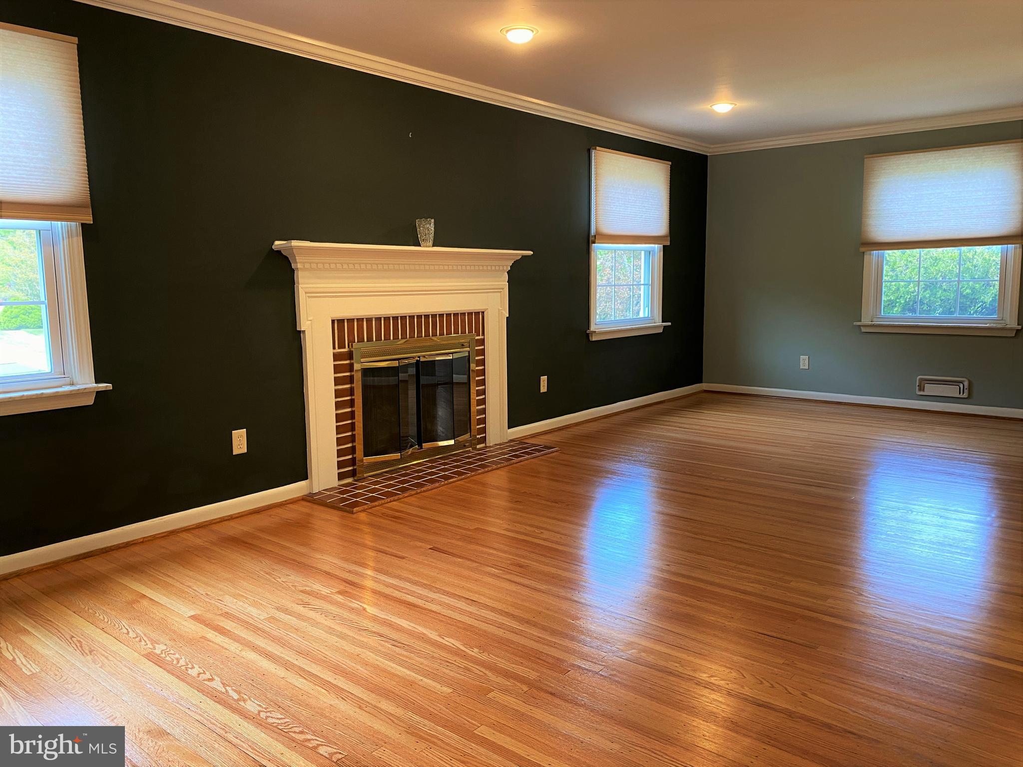 555 Tarrington Road Cherry Hill, NJ 08034 - Photo 8 of 19 an empty room with wooden floor fireplace and windows