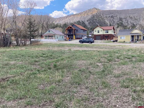 a view of a big house with a big yard and large trees