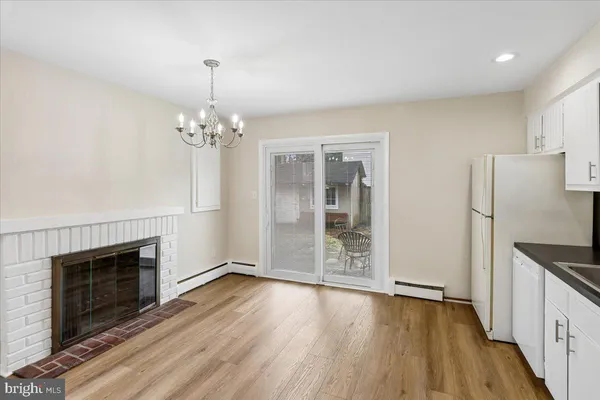 an empty room with wooden floor fireplace and windows