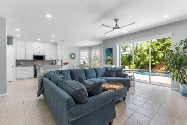 a kitchen with stainless steel appliances kitchen island granite countertop a stove top oven a sink a dining table and chairs with wooden floor