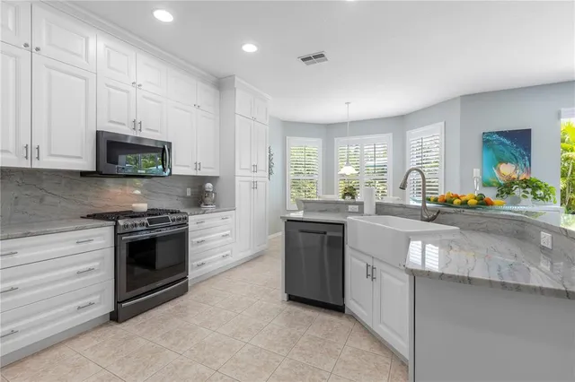 a spacious bedroom with a bed and a flat tv screen on dresser