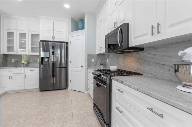 a bathroom with a tub a double vanity sink and mirror with window