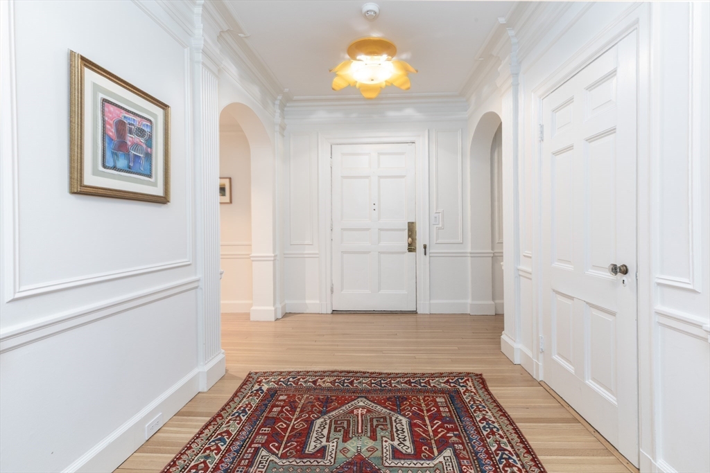 62 Beacon Street, Unit 3 Boston, MA 02108 - Photo 5 of 25 a view of a hallway with wooden floor and a rug
