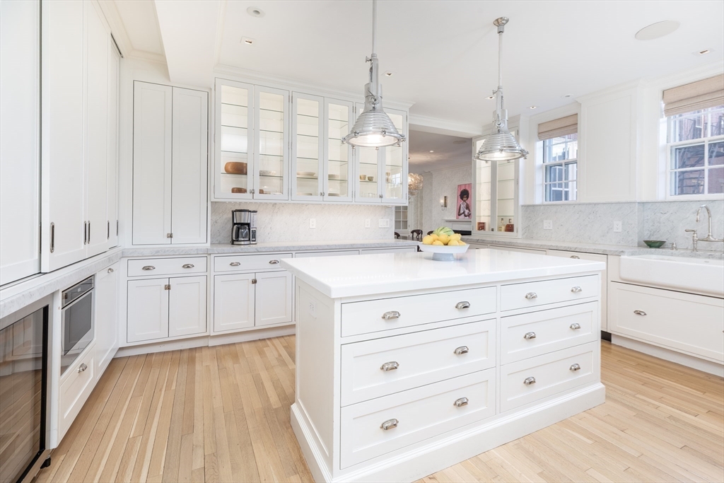 62 Beacon Street, Unit 3 Boston, MA 02108 - Photo 6 of 25 a kitchen with stainless steel appliances white cabinets and wooden floors