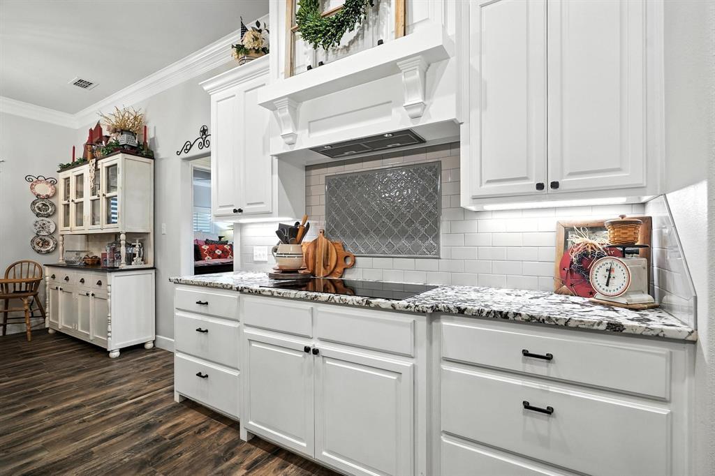 136 Dove Run Tuscola, TX 79562 - Photo 13 of 36 Kitchen featuring ventilation hood, light stone counters, and dark wood finished floors