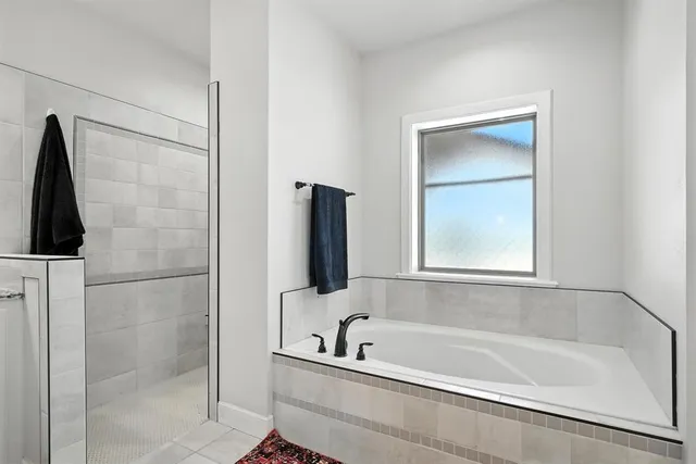 a bath room with a bath tub and a mirror