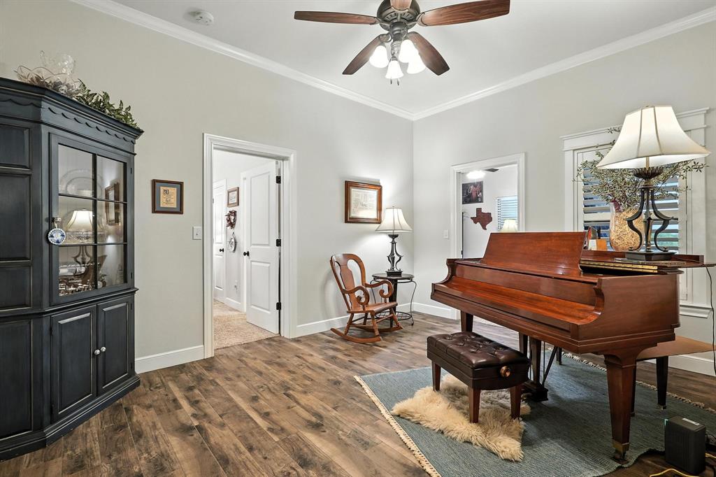 136 Dove Run Tuscola, TX 79562 - Photo 24 of 37 Living area featuring crown molding, dark wood-style floors, and a ceiling fan