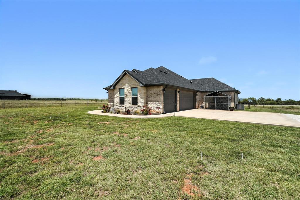 136 Dove Run Tuscola, TX 79562 - Photo 37 of 37 Side of home featuring a three car garage and concrete driveway