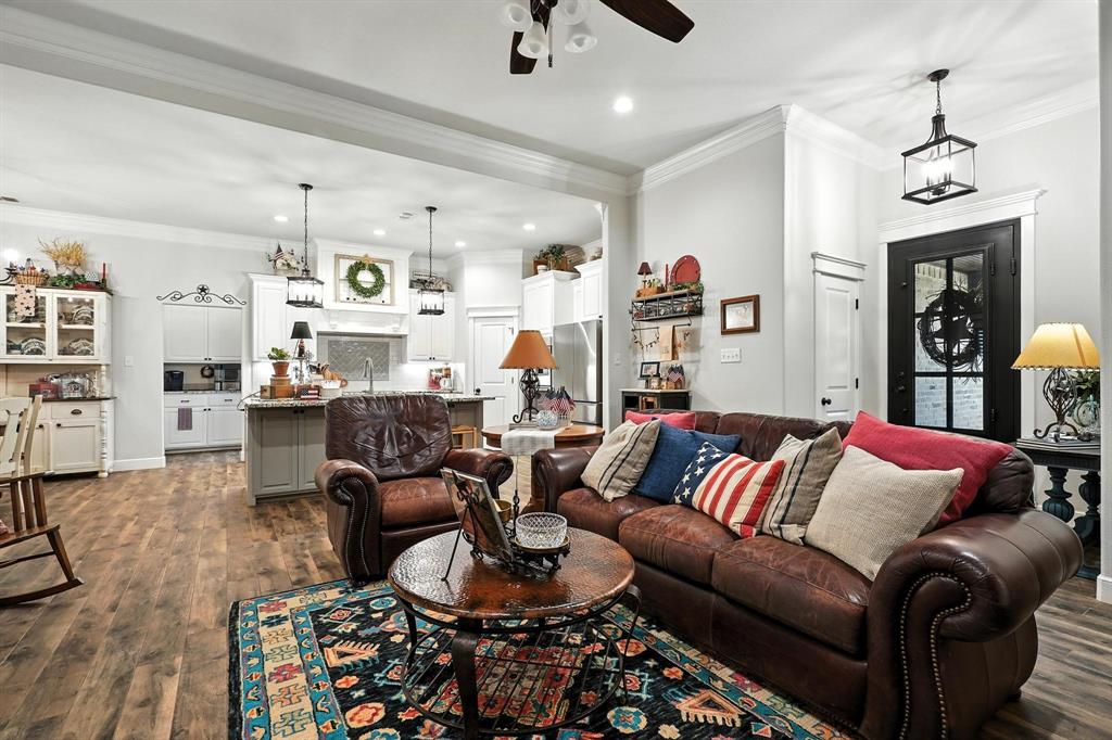 136 Dove Run Tuscola, TX 79562 - Photo 7 of 36 Living room featuring crown molding, wood finished floors, a stone fireplace, ceiling fan, and recessed lighting