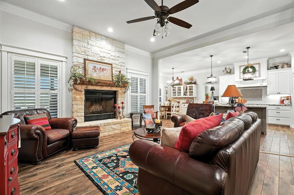 136 Dove Run Tuscola, TX 79562 - Photo 9 of 37 Living room featuring crown molding, wood finished floors, a stone fireplace, ceiling fan, and recessed lighting