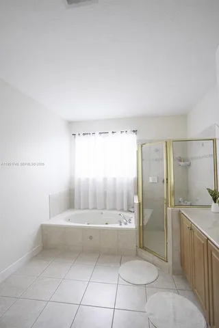 a bathroom with a tub shower and sink