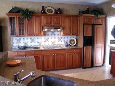 a kitchen with granite countertop a refrigerator and a stove