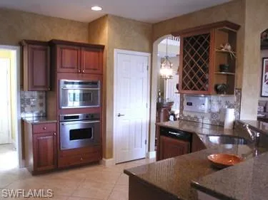 a kitchen with granite countertop a stove and cabinets
