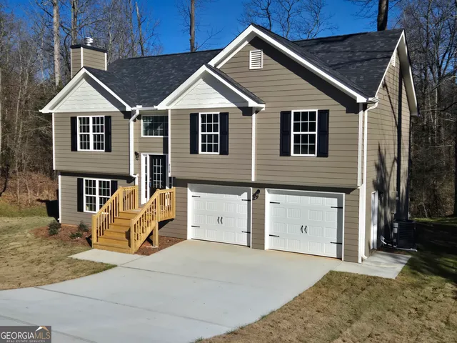 a view of a white house with iron fence