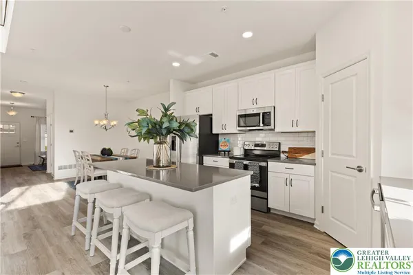 a kitchen with microwave a refrigerator and cabinets