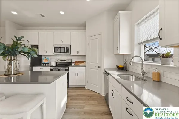 a kitchen with sink a microwave and cabinets