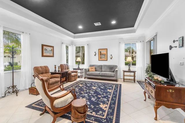 a kitchen with kitchen island granite countertop a stove a sink a refrigerator and white cabinets with wooden floor