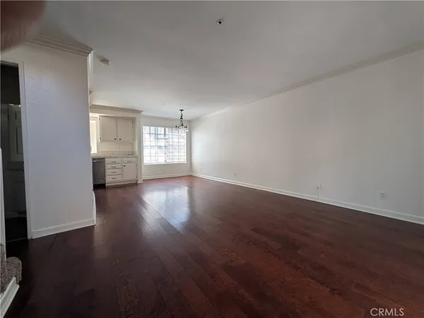 a view of empty room with window and wooden floor