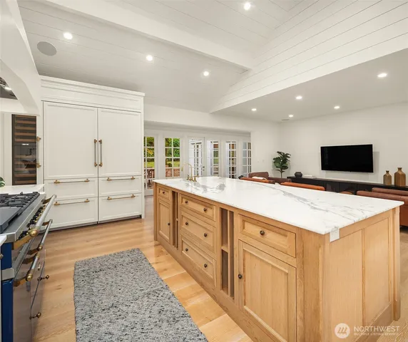 a large kitchen with stainless steel appliances a large counter top a stove and a refrigerator