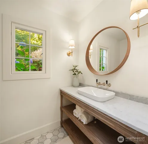 a bathroom with a granite countertop double vanity and a mirror