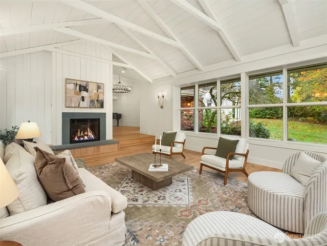 a living room with furniture large window and fireplace