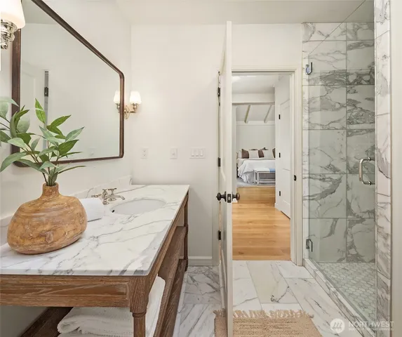 a bathroom with a granite countertop shower a sink and a mirror