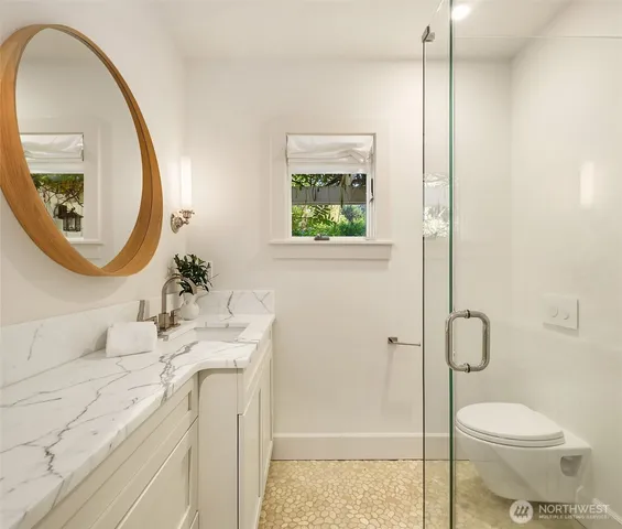 a bathroom with a sink a toilet and a mirror