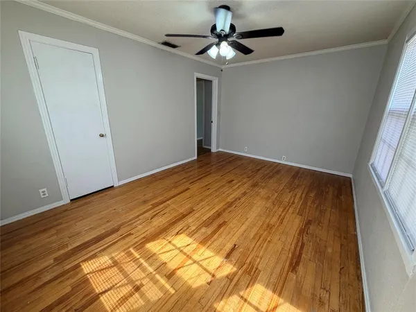 a view of empty room with wooden floor