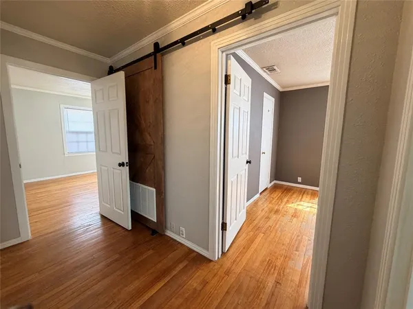 a view of a hallway with wooden floor and staircase
