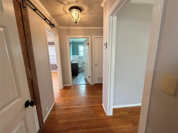 a view of a hallway with wooden floor