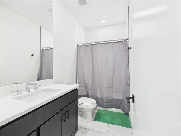 a bathroom with a sink a toilet a shower and a mirror