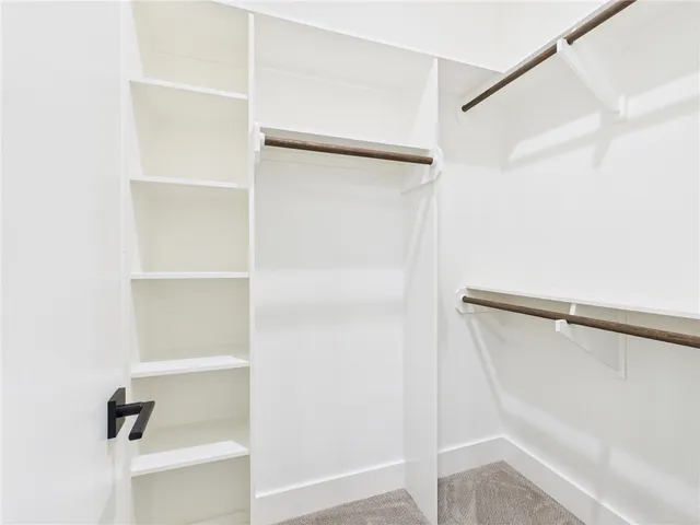 a view of walk in closet with empty racks