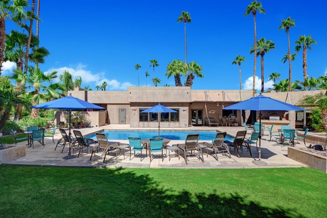 a view of a patio with table and chairs under an umbrella