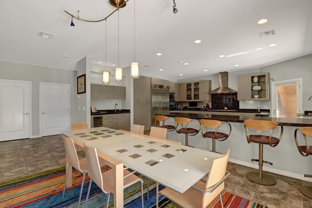a kitchen with a dining table chairs and refrigerator