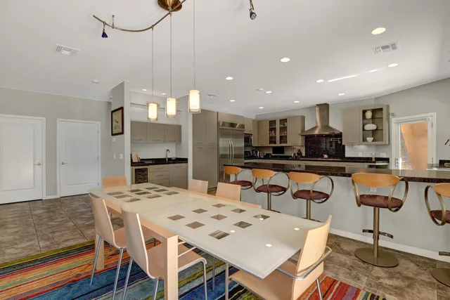 a kitchen with a dining table chairs and refrigerator