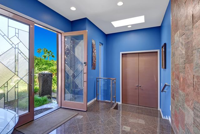 a view of an entryway with a floor to ceiling window and wooden floor