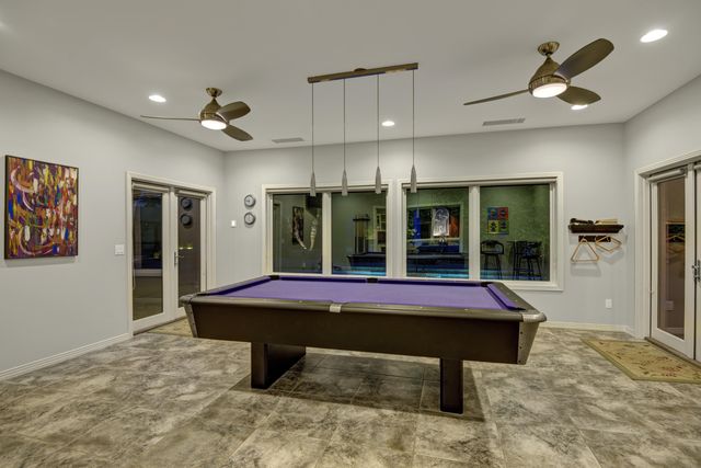 a room with pool table and windows
