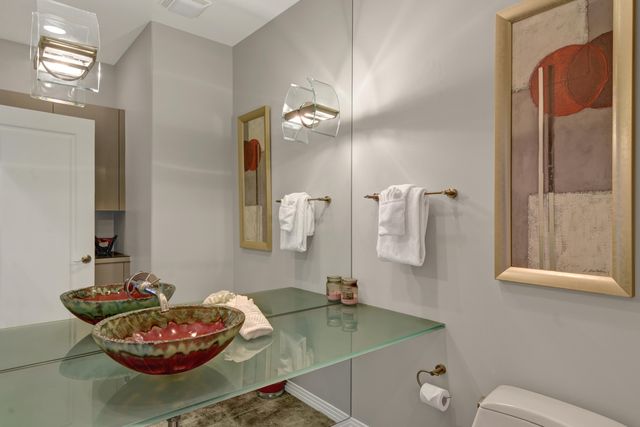 a bathroom with a granite countertop sink a toilet and a mirror