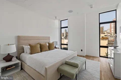 a bedroom with a bed and a mirror on the dresser