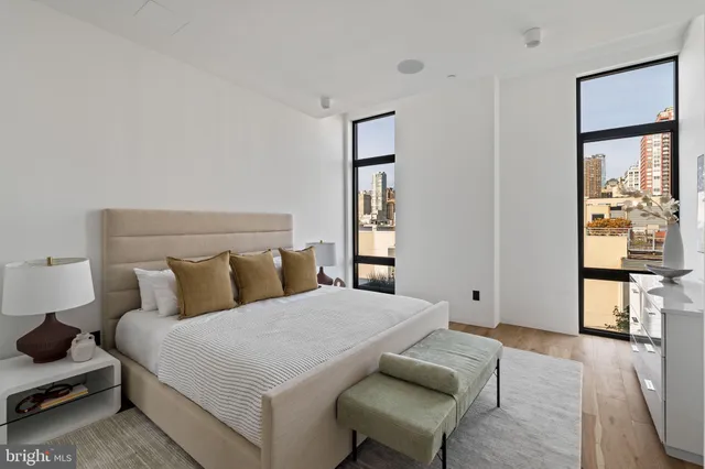 a bedroom with a bed and a mirror on the dresser