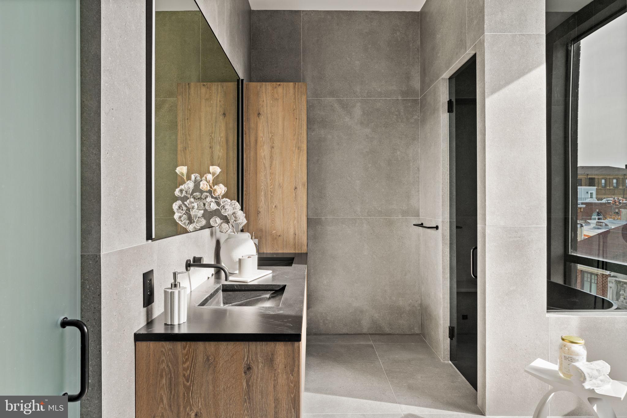 1428 Kenilworth Street Philadelphia, PA 19146 - Photo 35 of 58 a bathroom with a granite countertop sink a mirror and a shower