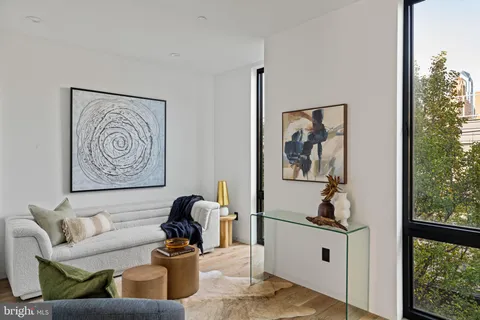 a living room with furniture wooden floor and a large window