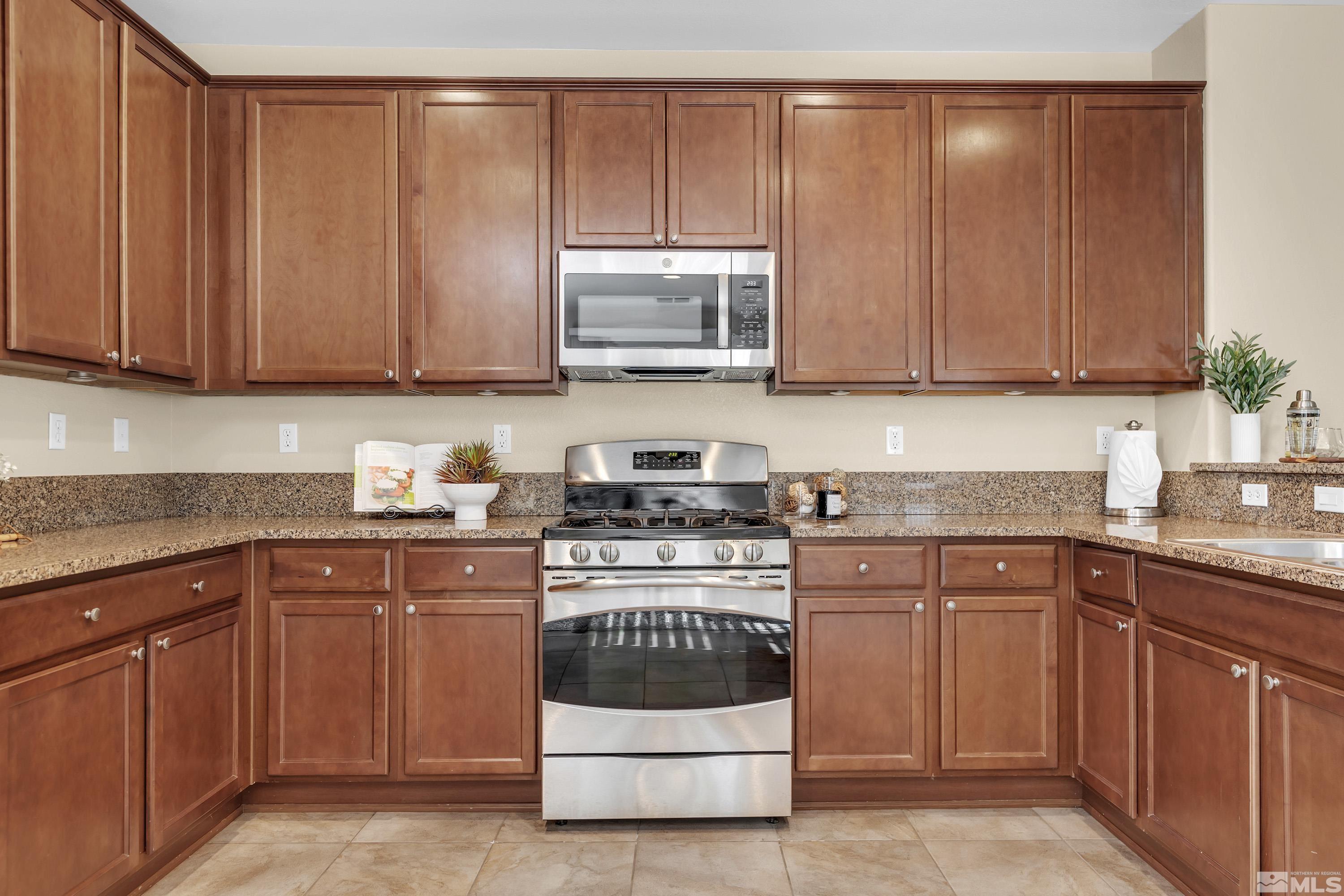 10797 Amber Falls Drive Reno, NV 89521 - Photo 27 of 38 a kitchen with granite countertop wooden cabinets and stainless steel appliances