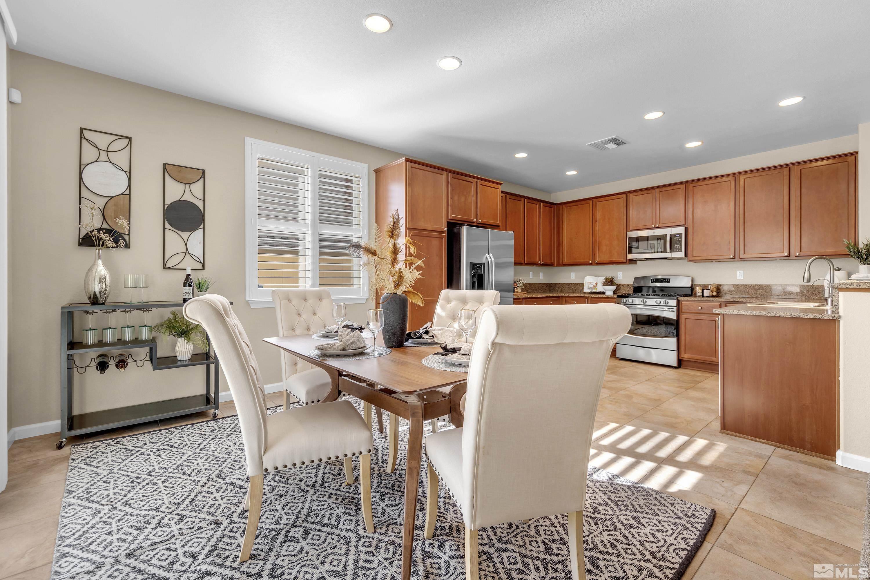 10797 Amber Falls Drive Reno, NV 89521 - Photo 6 of 38 a kitchen with a table chairs refrigerator and microwave
