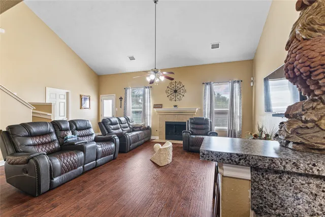 a living room with fireplace furniture and a wooden floor