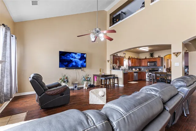 a living room with furniture kitchen view and a chandelier