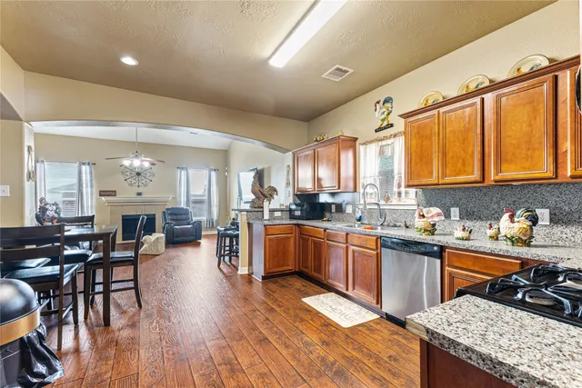 a kitchen with stainless steel appliances granite countertop sink stove top oven and cabinets