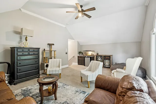 a living room with furniture a ceiling fan and a rug